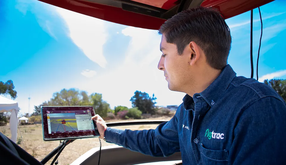 Trabajador utilizando pantalla de autoguiado para tractores